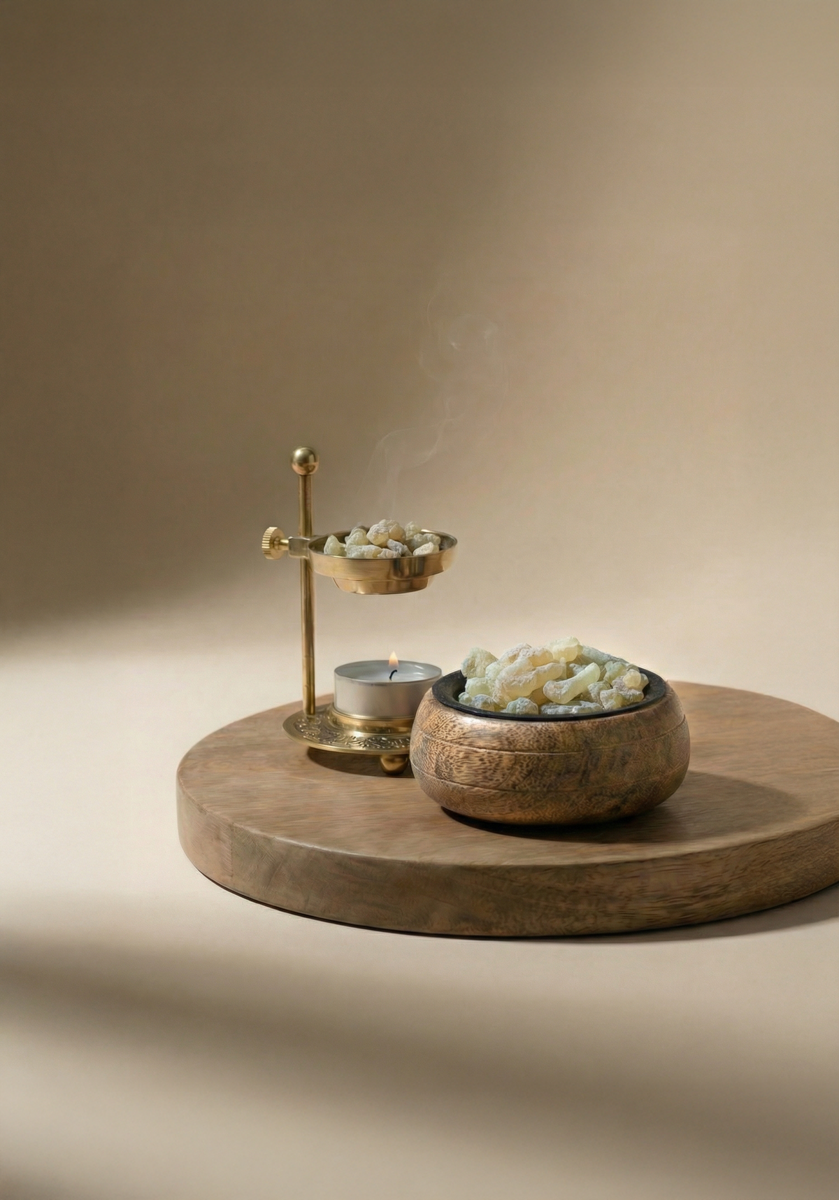 Setup ritual complet pentru fumigație cu tămâie Boswellia Sacra: granulații de rășină naturală în bol din alamă gravat, încălzitor tradițional și lumânare aprinsă pe taler din lemn
